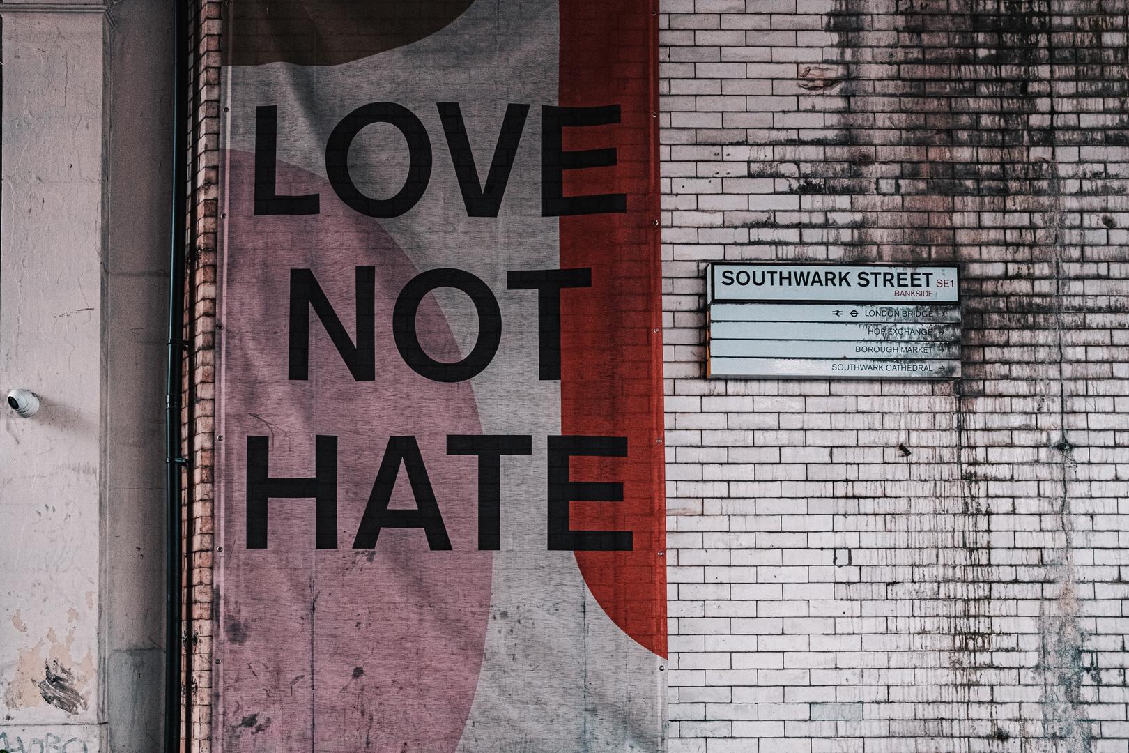 Buntes Banner an einer Wand mit den Worten Love Not Hate