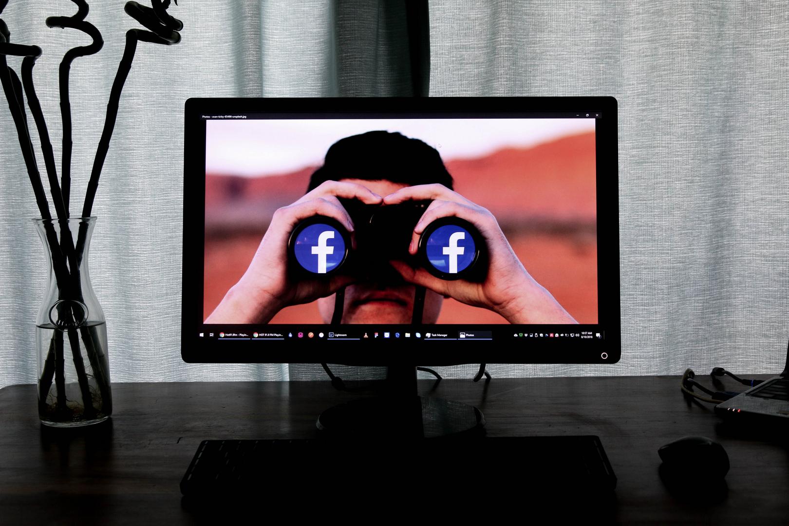 Mann mit Facebook Fernglas auf einem Monitor