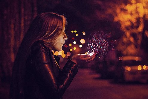 Mädchen pustet Glitzerstaub