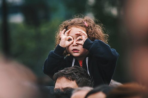 Mädchen tut so als ob sie ein Fernglas benutzt