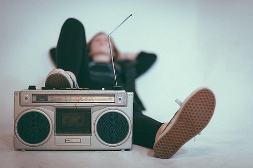 Jungendlicher hört Podcast mit Musikbox