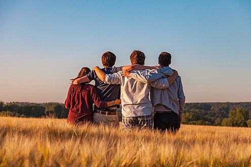 Vier Freunde stehen auf einem Feld