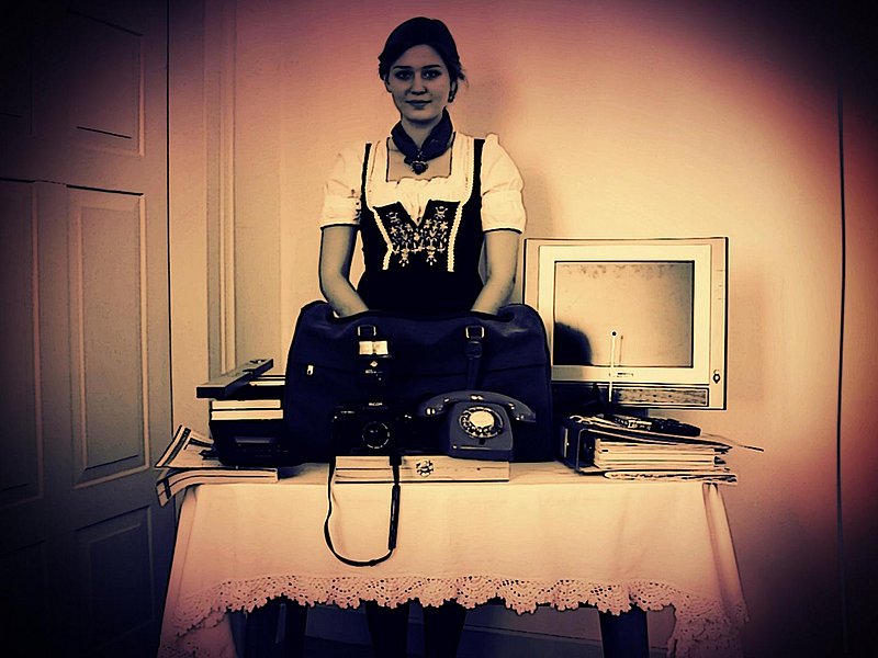 Frau hinter Tisch mit vielen Gegenständen