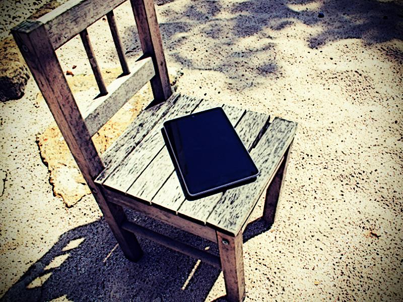 Smartphone auf Stuhl im Sand