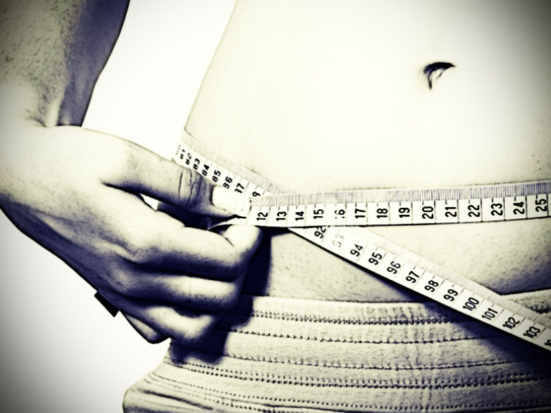 Mädchen mit Essstörung misst Bauchumfang