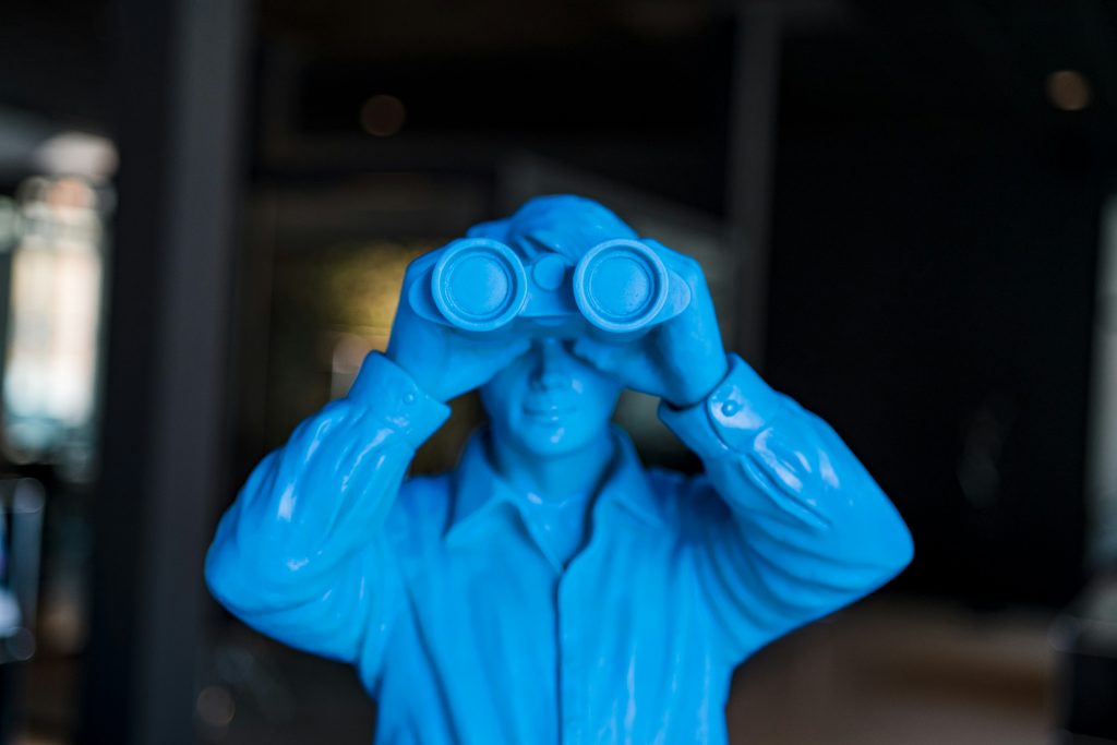 blaue Figur mit einem Fernglas