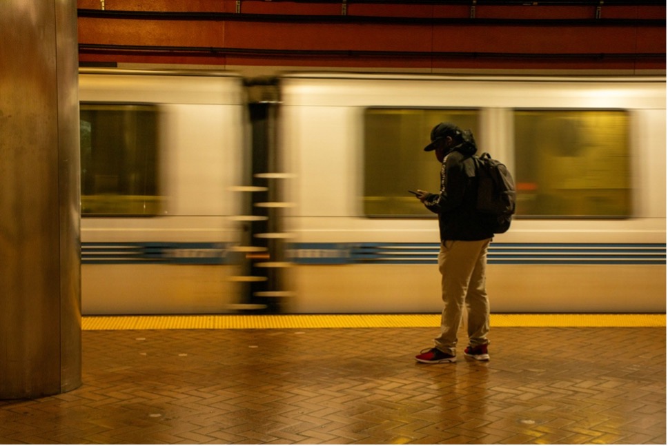 Junger Mann in der U-Bahnstation mit Handy